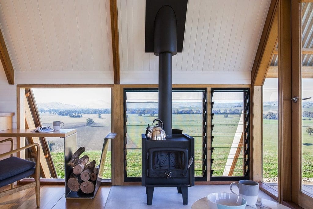 This Elegant A-Frame Rental in Australia Lets You Reconnect With Nature in Style 5 a freestanding nectre wood burning stove provides extra warmth in winter while operable louvers let in cooling breezes in summer
