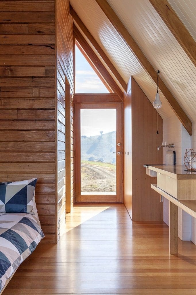 This Elegant A-Frame Rental in Australia Lets You Reconnect With Nature in Style 10 the whitewashed shiplap silvertop ash sloped walls contrasts with the v groove pine that wraps around the bathroom