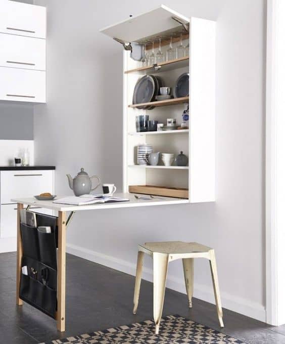 Small Kitchen Hacks: 25 Simple Tricks to Maximize Your Space and Efficiency 10 A space-saving fold-down table attached to the wall in a small kitchen, providing additional counter space when needed.