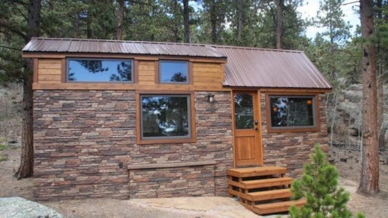 his rustic stone cottage is a 204 sq.ft. tiny house on wheels created by Simblissit