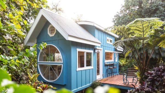 This modern tiny house in Hawaii is clad in teal-painted plywood and a metal roof that's pitched in the front and curved in the rear.