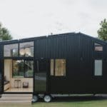 This Off-Grid Tiny Home Packs a Powerful Kitchen Into 183 Square Feet 31 The First Light tiny home is sided with black corrugated steel and features expansive windows and French doors that connect the plywood interior to the outdoors.
