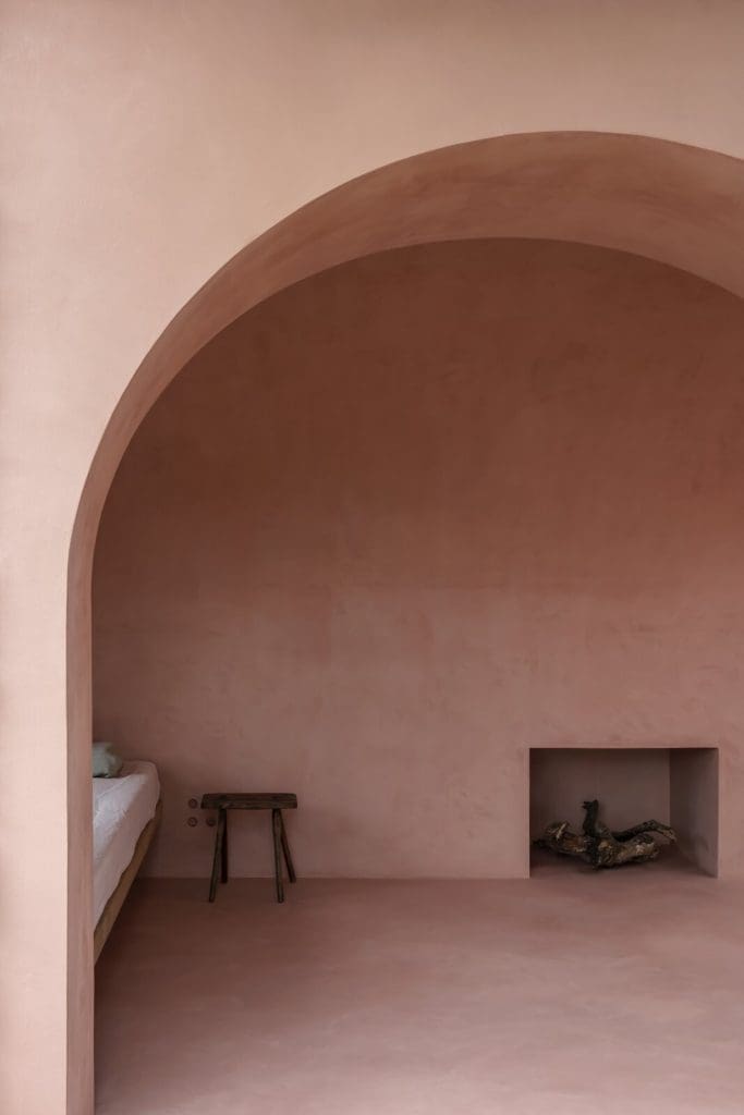 A Pair of Pink and Purple Tiny Houses Take Root in an Idyllic Olive Grove 3 a fireplace near the bedroom