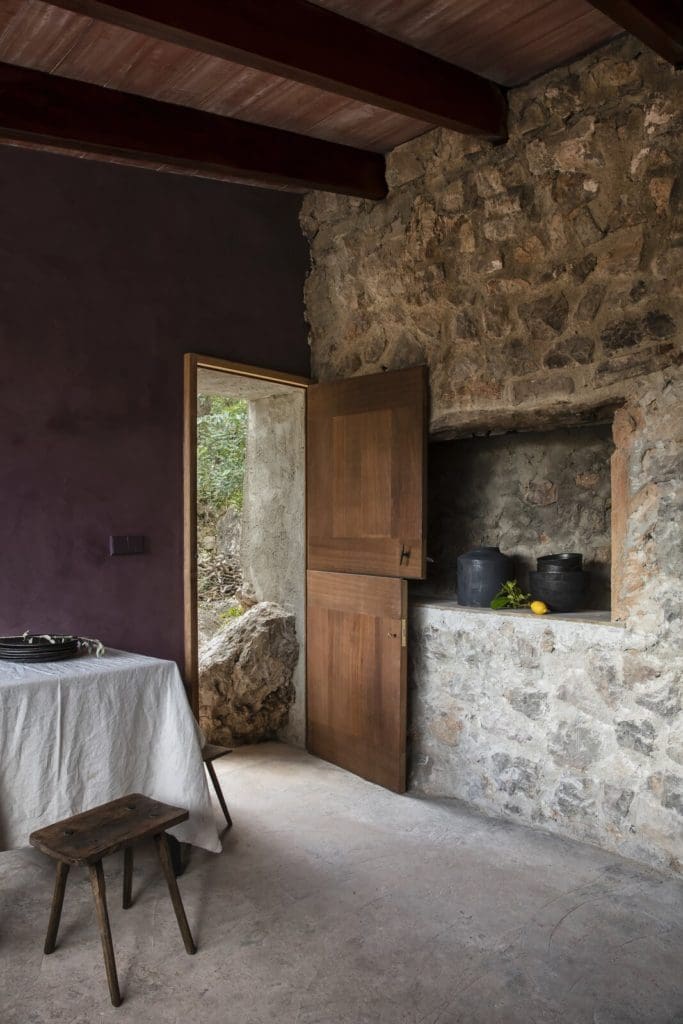 A Pair of Pink and Purple Tiny Houses Take Root in an Idyllic Olive Grove 7 purple walls contrast with stone masonry and introduce a modern sensibility