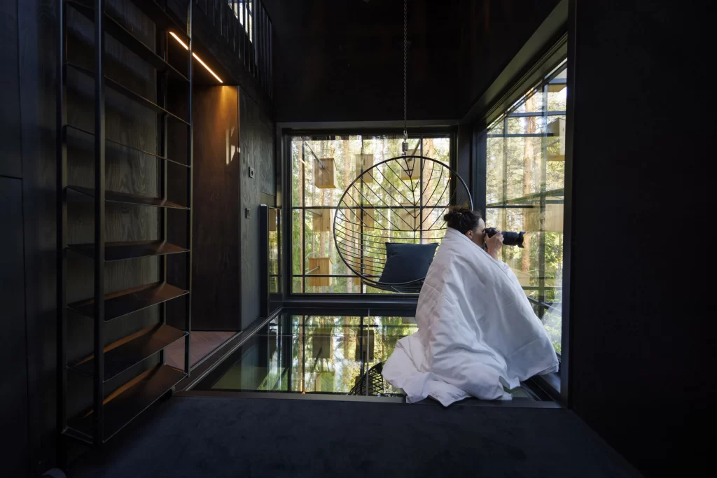 The Extraordinary 350 Birdhouse Hotel Room Hidden in a Swedish Forest 8 A guest enjoying an intimate birdwatching experience from the comfort of the Birdhouse Hotel Room.