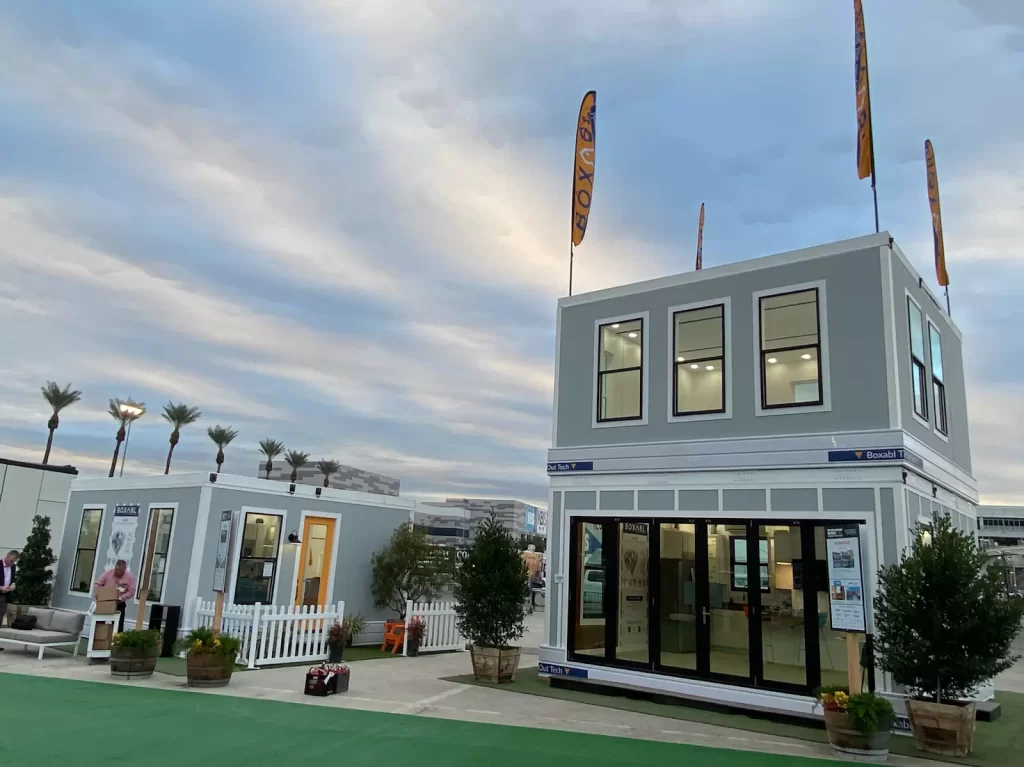Boxabl Homes: The Future of Affordable Housing 5 A side-by-side comparison of a Boxabl home and a traditional house, illustrating the differences in construction methods and materials.