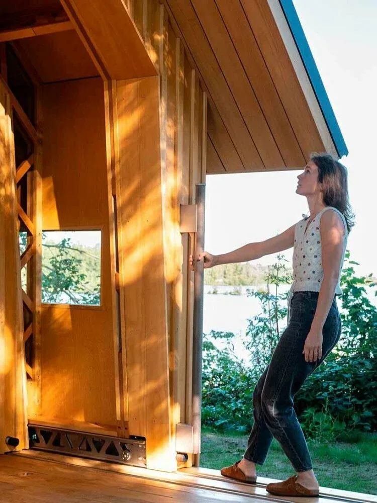 The Innovative Wooden Cabin: A Sliding Double-Shell Design by Caspar Schols 9 A homeowner performing routine maintenance on their wooden cabin.