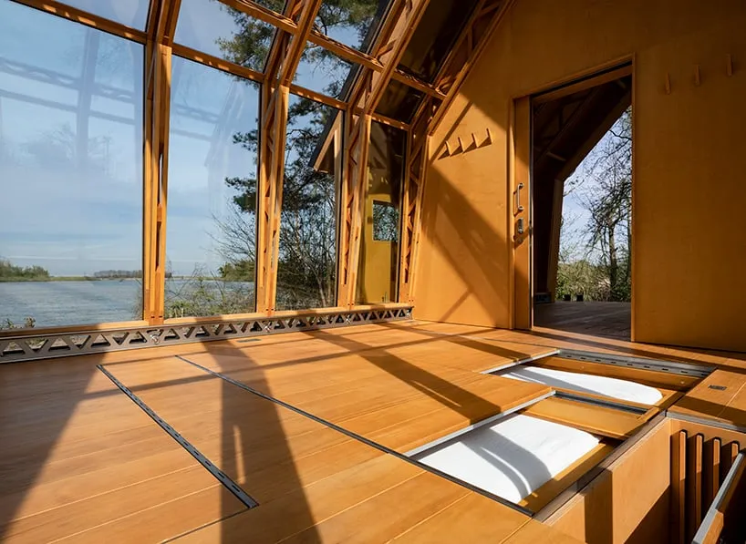 The Innovative Wooden Cabin: A Sliding Double-Shell Design by Caspar Schols 5 A wooden cabin featuring expansive windows that connect the interior with the surrounding nature.